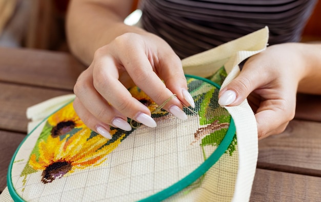 Kobieta wyszywa kolorowy wzór